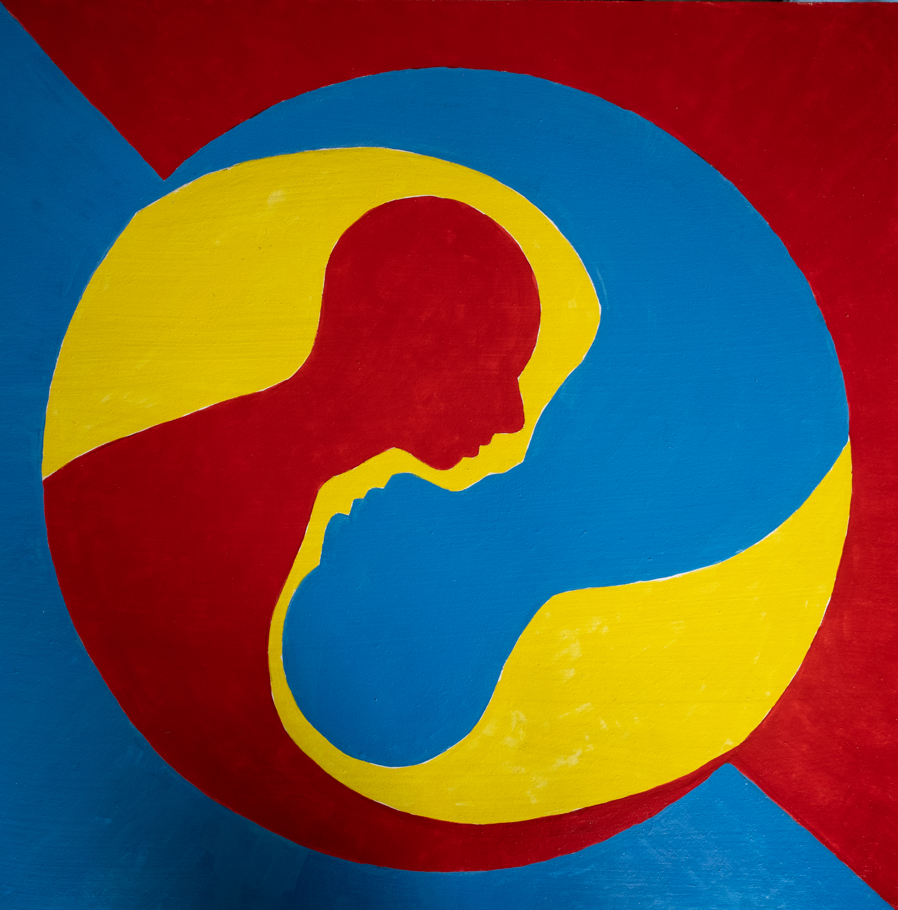 Nested red and blue human profiles within yellow, red and blue circular forms